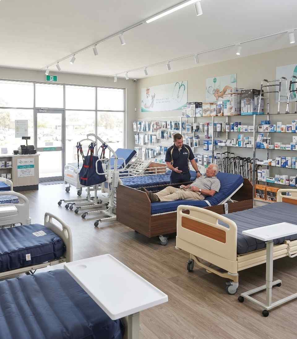 Aydınlık medikal teşhir salonunda hasta yatakları ve görevliler (temsili görsel)